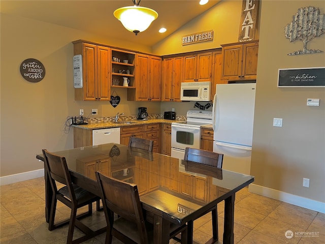 kitchen featuring light tile patterned floors, vaulted ceiling, sink, decorative light fixtures, and white appliances