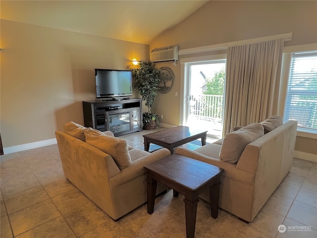 living room featuring a healthy amount of sunlight, an AC wall unit, light tile patterned floors, and vaulted ceiling