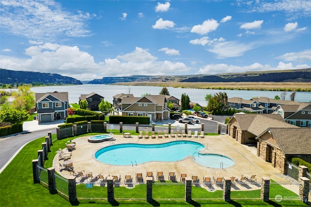 view of pool featuring a community hot tub, a patio, and a water and mountain view