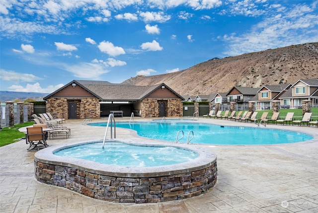 view of swimming pool featuring a mountain view, a patio area, and a community hot tub