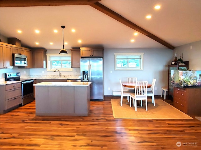 kitchen with appliances with stainless steel finishes, sink, hanging light fixtures, and vaulted ceiling with beams