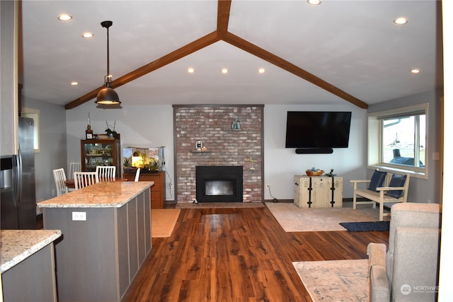 living room featuring a fireplace, vaulted ceiling with beams, and dark hardwood / wood-style floors