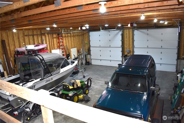 garage featuring a garage door opener and wood walls