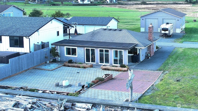 rear view of property with a patio, a storage shed, and a yard