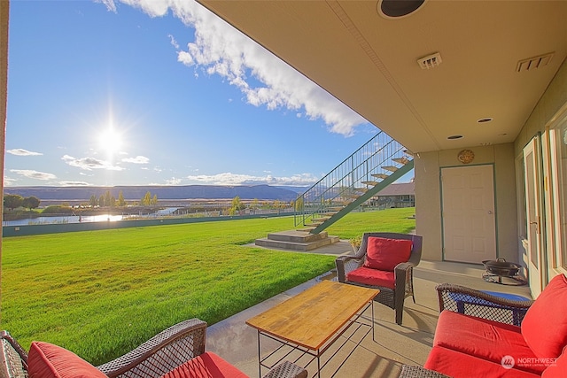 view of patio with an outdoor living space and a water and mountain view