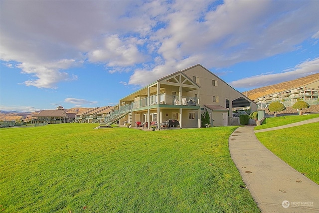 back of house with a yard, stairway, and a deck