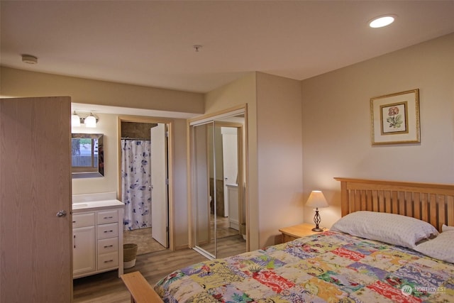 bedroom with wood finished floors, recessed lighting, and a closet