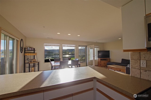 kitchen featuring recessed lighting, open floor plan, white cabinetry, and plenty of natural light