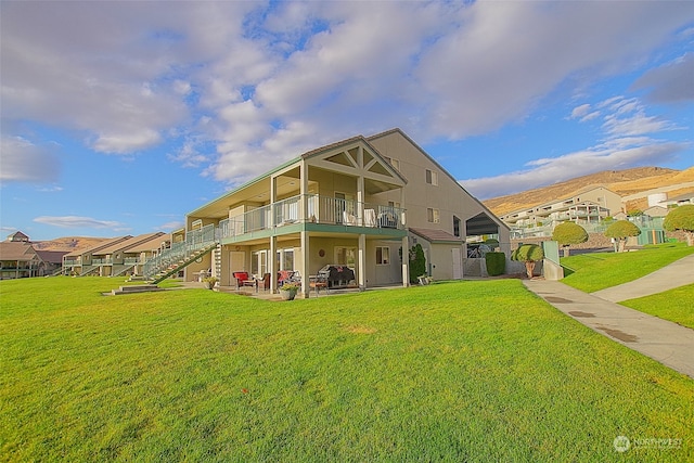 rear view of property with a yard and a balcony