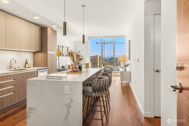 kitchen featuring backsplash, dark hardwood / wood-style flooring, sink, decorative light fixtures, and a center island