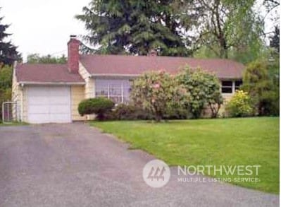 ranch-style home with a front yard and a garage