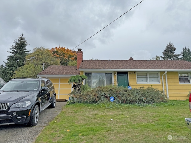 single story home featuring a front lawn