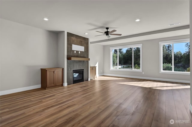 unfurnished living room featuring ceiling fan, light hardwood / wood-style flooring, and a tile fireplace