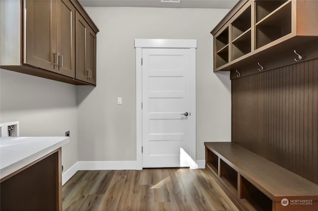 washroom featuring washer hookup, wood-type flooring, cabinets, and hookup for an electric dryer