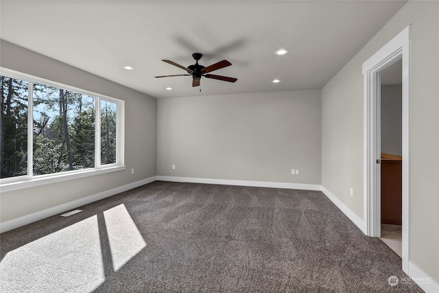 empty room with dark carpet and ceiling fan