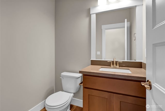 bathroom featuring vanity, hardwood / wood-style floors, and toilet