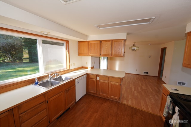 kitchen featuring hardwood / wood-style flooring, kitchen peninsula, white dishwasher, sink, and electric range