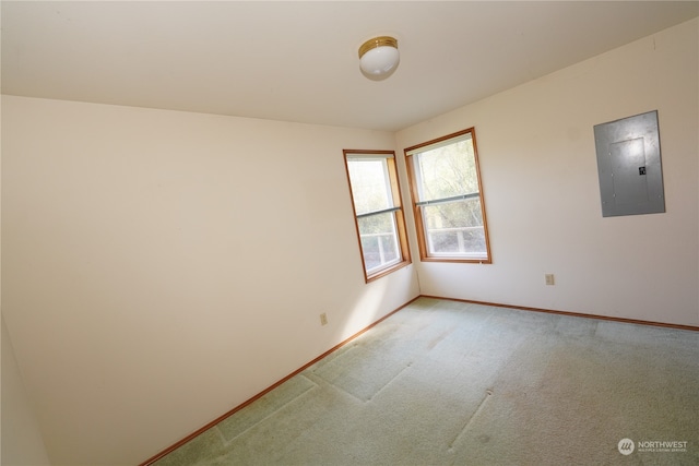 spare room with electric panel and light colored carpet