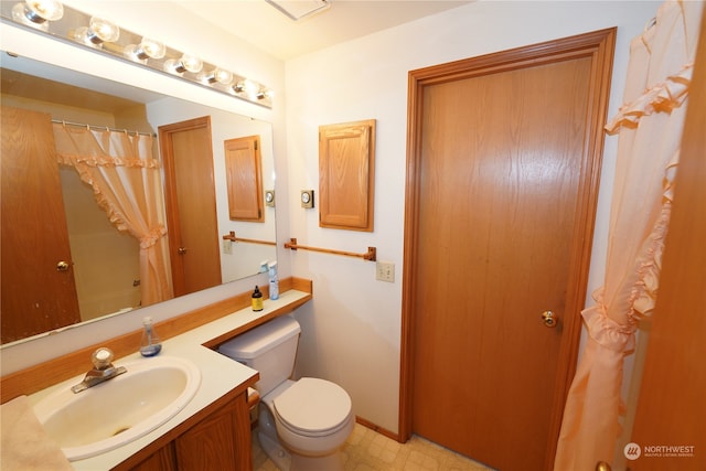 bathroom featuring vanity, toilet, and walk in shower