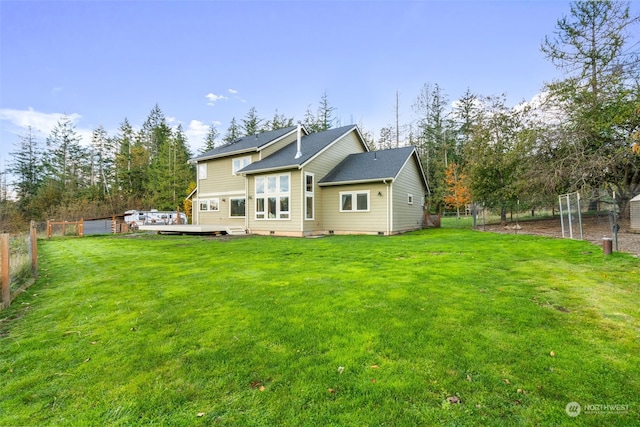 rear view of property with a yard, fence, and a wooden deck