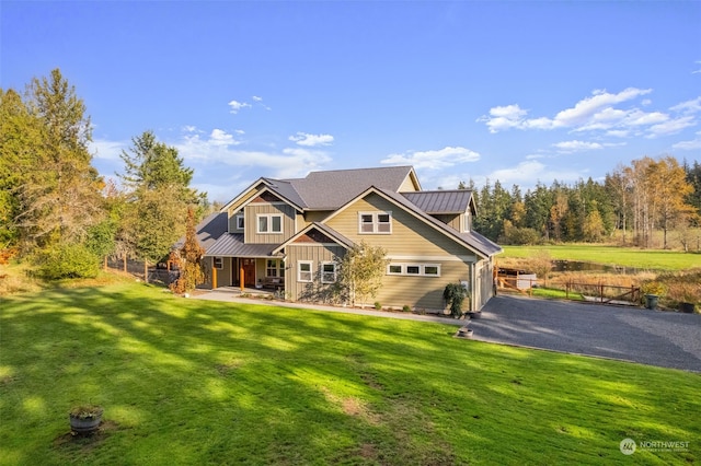 view of front of property with metal roof, a front lawn, a standing seam roof, and fence