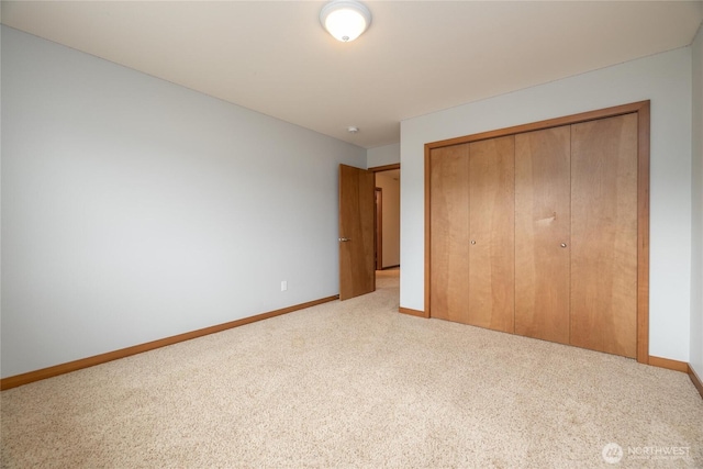 unfurnished bedroom featuring a closet, carpet flooring, and baseboards