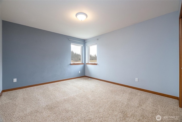 carpeted spare room featuring baseboards