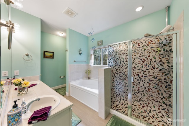 bathroom featuring vanity and shower with separate bathtub