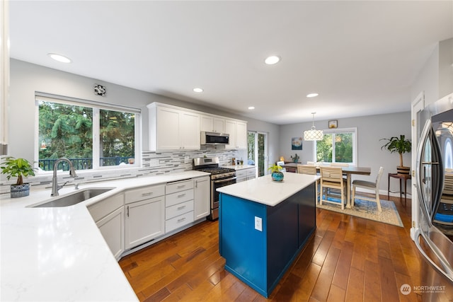 kitchen featuring pendant lighting, white cabinetry, dark wood-type flooring, and stainless steel appliances