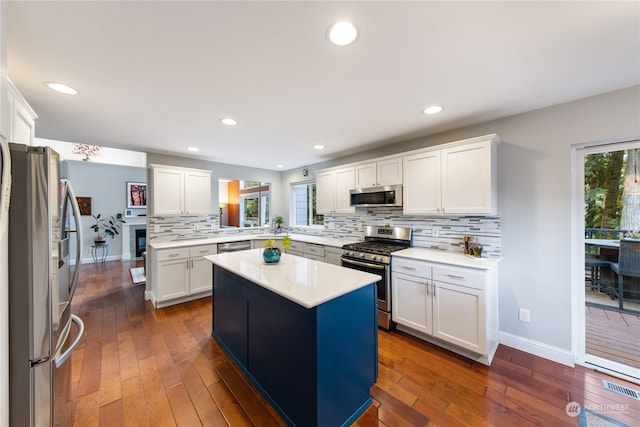 kitchen featuring a kitchen island, stainless steel appliances, white cabinetry, and dark wood-type flooring