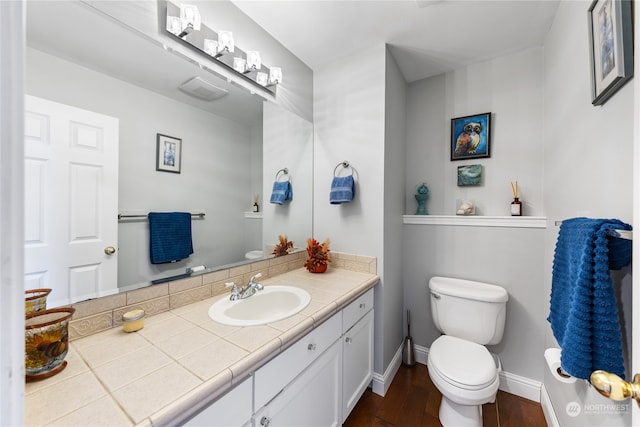 bathroom featuring toilet, vanity, and hardwood / wood-style flooring