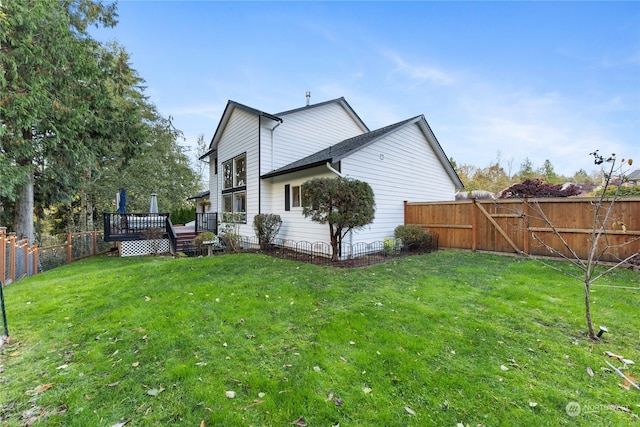 view of side of home featuring a yard and a deck