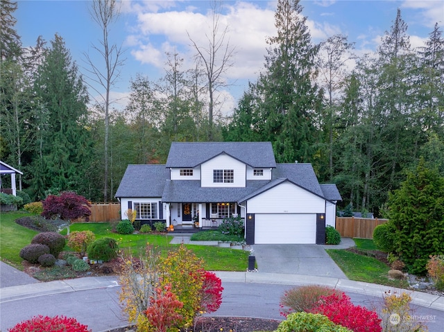 view of front of house with a porch, a garage, and a front lawn