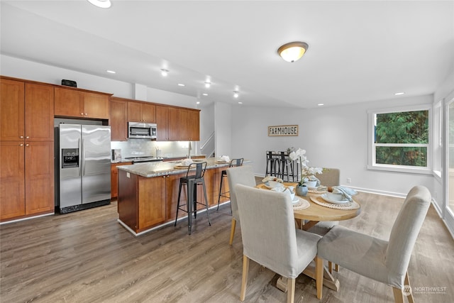 dining area with light hardwood / wood-style floors and sink