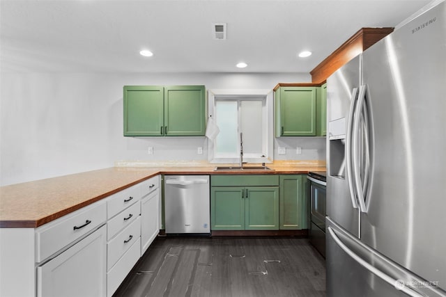 kitchen featuring kitchen peninsula, dark hardwood / wood-style flooring, appliances with stainless steel finishes, white cabinetry, and sink