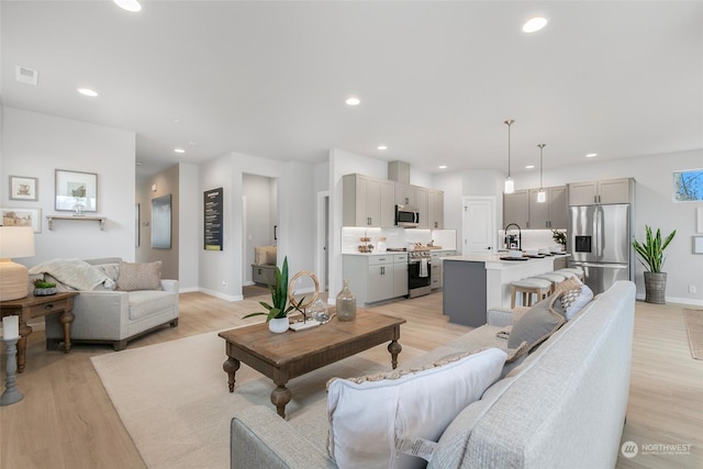 living room featuring light wood-type flooring and sink