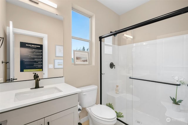 bathroom featuring vanity, toilet, and a shower with shower door