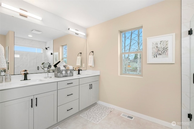 bathroom with tile patterned floors, vanity, and an enclosed shower