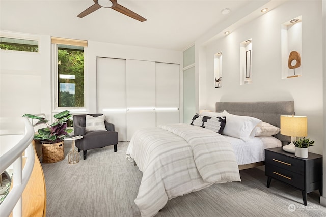 carpeted bedroom with ceiling fan and a closet