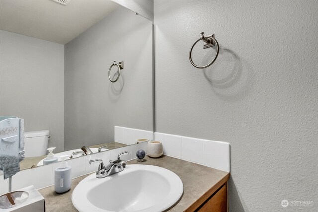 bathroom featuring vanity and toilet