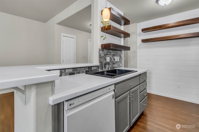 kitchen featuring dishwasher, gray cabinetry, hardwood / wood-style floors, sink, and decorative light fixtures