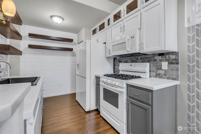 kitchen with decorative backsplash, sink, white cabinets, white appliances, and dark hardwood / wood-style flooring