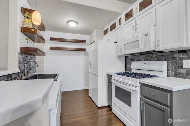 kitchen featuring white appliances, sink, dark hardwood / wood-style flooring, decorative light fixtures, and white cabinets