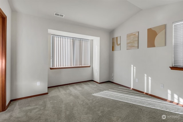 unfurnished room featuring light carpet and vaulted ceiling