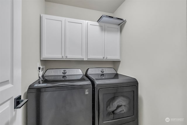 washroom featuring independent washer and dryer and cabinets