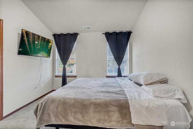 carpeted bedroom with lofted ceiling