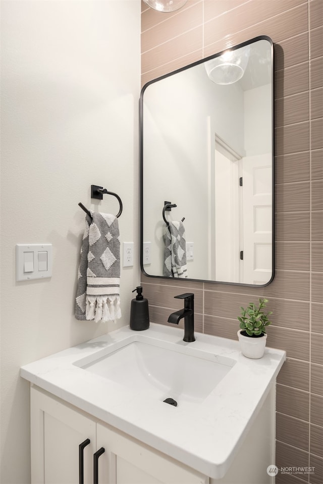 bathroom with vanity and tile walls