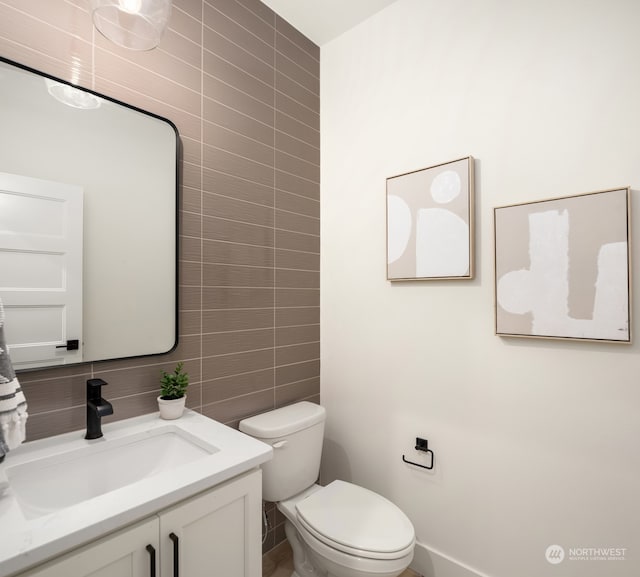 bathroom with vanity, toilet, tile walls, and backsplash