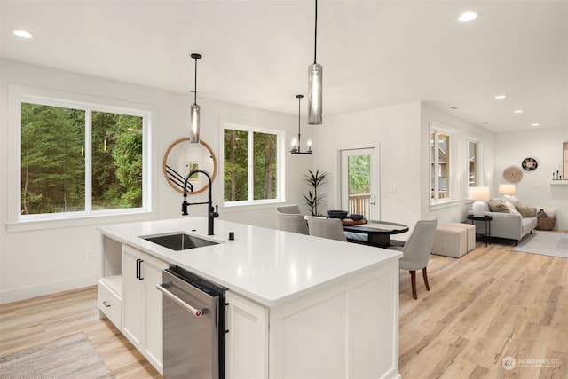 kitchen featuring a wealth of natural light, sink, pendant lighting, and light hardwood / wood-style flooring