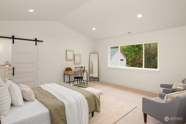 carpeted bedroom with a barn door and vaulted ceiling